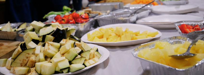 An image of containers of delicious-looking, plant-based food on a laden buffet table.
